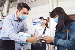 公共交通管理中心副主任黎煌向乘坐巴士的乘客贈送口罩和洗手液。