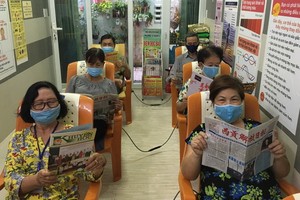 越、華婦女在閱覽室閱讀書報。