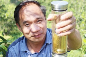 范武慶與來自山羅省塔殊鄉原料區的茶壺。