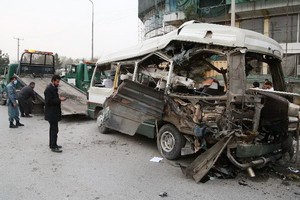3月15日，首都喀布爾一輛汽車遭炸彈襲擊，造成至少15人受傷，市政人員在清理爆炸現場。（圖源：新華社）