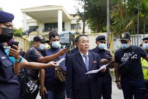 圖為3月21日朝鮮駐馬來西亞大使館臨時代辦金裕成在使館門外宣讀聲明。 （圖源：AP）