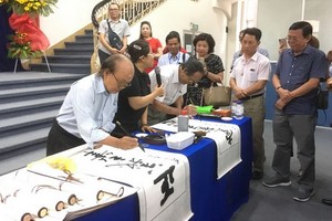 人民藝人張路書畫家（左一）現場揮毫書法。