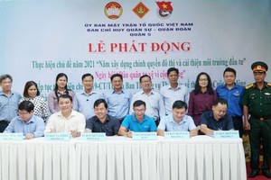 第五郡越南祖國陣線委員會副主席陳南德(右三前排)與第三、六、八、十、十四坊人委會簽署備忘錄。