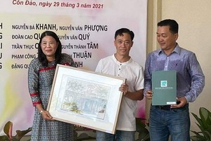 華人畫家羅漢榮(中)向崑崙島博物館代表贈送畫作。