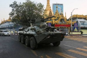 一輛裝甲車行駛在仰光街頭上。（圖源：路透社）