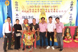 該廟理事長凌欽廷(右三)移交投得觀音慈袍給黃世英與家人。