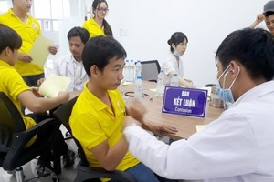 醫生在為勞動者查體。（示意圖源：垂楊）