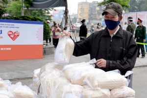 新冠肺炎疫情對我國經濟帶來顯著的影響。圖為一名家境困難者在領取免費食品。（圖源：秋莊）