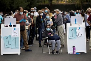 民眾在加州迪士尼樂園度假區接種疫苗的地點排長隊等候。（圖源：路透社）