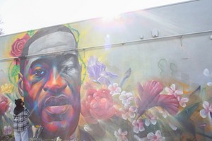 一名女子在喬治‧弗洛伊德的壁畫前表達敬意。（圖源：路透社）