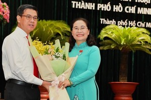 市人民議會主席阮氏麗（右）向阮文勇同志（左）贈送鮮花表示祝賀。