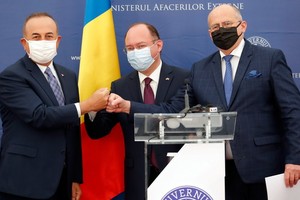 4月23日，在羅馬尼亞首都布加勒斯特，羅馬尼亞外長奧雷斯庫（中）、波蘭外長拉烏（右）和土耳其外長恰武什奧盧在聯合記者會上碰拳。 （圖源：新華社）