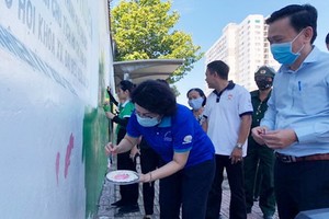 市越南祖國陣線委員會主席蘇氏碧珠與各代表一同塗鴉宣傳壁畫。（圖源：市越南祖國陣線委員會）