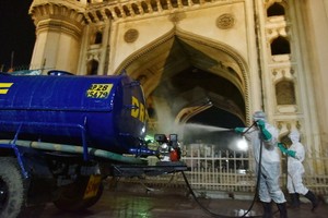 工作人員在印度海得拉巴夜間宵禁時進行消殺作業。（圖源：新華社）