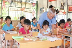 吳松碧教師在給邊界清貧學生練字。