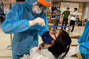 口岸防疫工作人員向一名入境者進行鼻拭子取樣測試。（圖源：VTV）