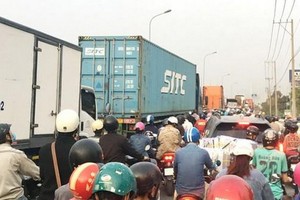 駛入守德市富友港的阮維貞街交通堵塞，摩托車與集裝箱車魚貫而行。
