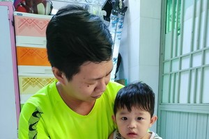 王鍾源抱著患癌症的幼兒家安。