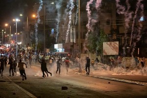 巴以衝突期間，加沙地區的建築群上空生起陣陣爆炸過後的煙霧。（圖源：新華社）