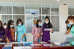 市婦聯會副主席林氏玉華（右三）、郡婦聯會主席梁菁竹在閱讀“推崇學習胡志明思想、道德與榜樣的集體與個人”特刊。