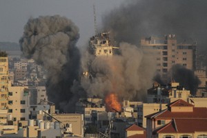 加沙城一處建築在以色列空襲中倒塌，現場升騰起濃煙。（圖源：互聯網）