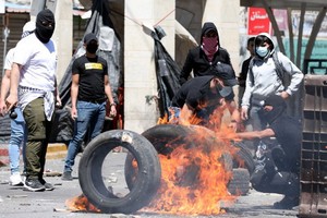 巴勒斯坦人在衝突中點燃了橡膠輪胎。（圖源：EPA）