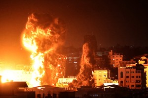 十七日清晨，加沙地帶的建築物上空升起了大火和濃煙。（圖源：AFP）