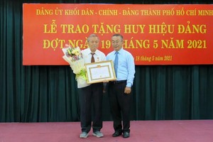 武玉國順同志（右）向阮煌同志（左）頒授55年黨齡紀念章及獎狀。（圖源：秋紅）