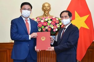 新任外交部副部長范光效（左）從外交部長裴青山手中接過人事委任《決定》。（圖源：國際報）