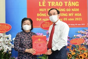 市委書記阮文年（右）向張美華同志（左）頒授60年黨齡紀念章。（圖源：越勇）