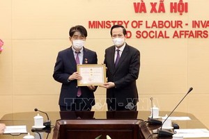 ILO駐越南首席代表李昌徽博士（左）榮獲“為勞動與榮軍社會事業”紀念章。（圖源：越通社）