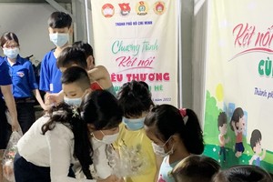 市越南祖國陣線委員會副主席潘嬌清香向平新貧困勞工的子弟贈送禮物。