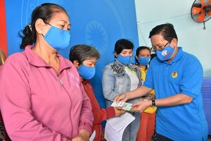  市勞動聯團常務委員、《勞動者報》總編輯蘇廷遵向第十二郡貧困者頒發CEP輔助金。（圖源：晉盛）