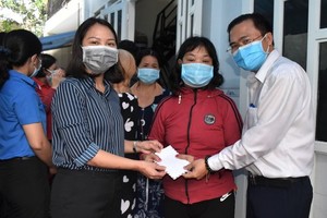 市人民議會辦公廳主任高清平（右一）慰問守德市遭嚴重水淹的民戶並贈送禮物。（圖源：廷理）