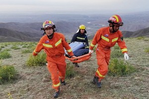 救援人員抬著擔架前往救援。（圖源：路透社）