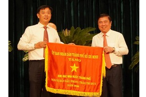 市人委會主席阮成鋒（右）向取得本市2020年競賽運動出色成績的單位頒發競賽錦旗。