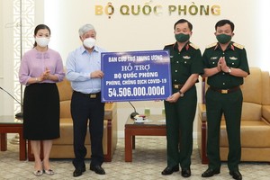 越南祖國陣線中央委員會主席杜文戰（左二）象徵性將各界同胞捐助抗疫的逾545億元款項轉交國防部。（圖源：潘草）