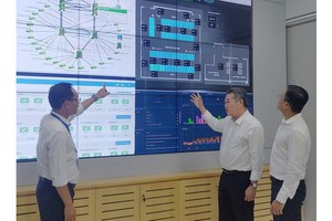 市電力總公司（EVNHCMC）理事會主席范國寶（中）考察市電力數據 中心管理室。