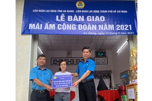 市勞動聯團領導（右）與安江省勞動聯團向文氏美家庭贈送“工會溫情屋”。