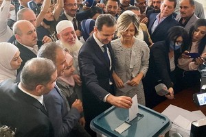 敘利亞總統巴沙爾·阿薩德和他的妻子阿斯瑪26日在敘利亞首都大馬士革附近的一個投票站投票。（圖源：路透社）