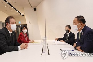 5月25日，在首爾東大門設計廣場舉行的全球綠色目標夥伴2030峰會（P4G）綠色新政特別會議上，南韓副總理兼企劃財政部長官洪楠基（右）和聯合國綠色氣候基金執行董事雅尼克·格萊馬雷克會面。（圖源：韓聯社）