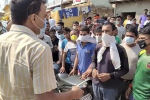 假酒中毒事件發生後，村民與一名官員交談。（圖源：PTI）