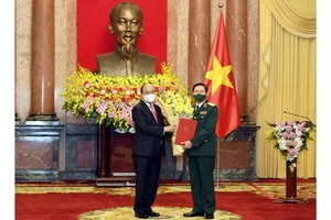 國家主席阮春福（左）向阮新剛上將頒授委任《決定》。（圖源：玉興）