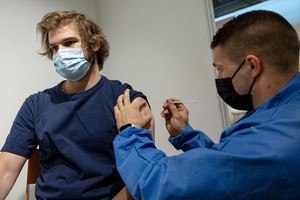 一名男子在法國巴黎凡爾賽門展覽中心設立的疫苗接種中心接種疫苗。（圖源：新華社）