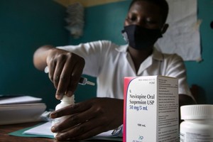 一名助產士為烏干達一個兩周大的艾滋病毒檢測呈陽性的嬰兒準備藥物。（圖源：聯合國）