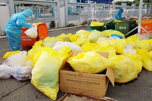 收集和處理醫療廢棄物的工人都穿著防護裝備。