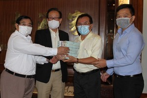 萬盛發集團代表張豐裕（左二）向二府會館理事會和建築公司代表移交最後一期捐款。