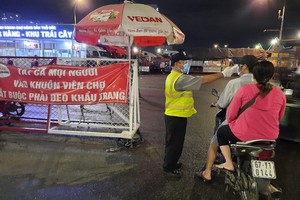 客人進入守德集散市場必須戴口罩並測量體溫。