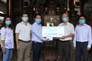 穗城會館理事長盧耀南(右二)和副理事長陳志豪(右一)向本報領導移交5000萬元贈款。