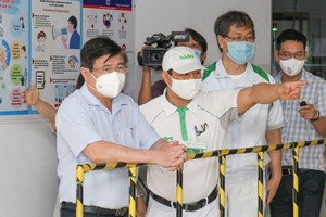 市人委會主席阮成鋒（左一）視察接種工作。